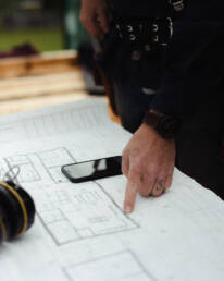 Building plans by Eisenhauer Woodworks with someone pointing to the corner of the floorplan
