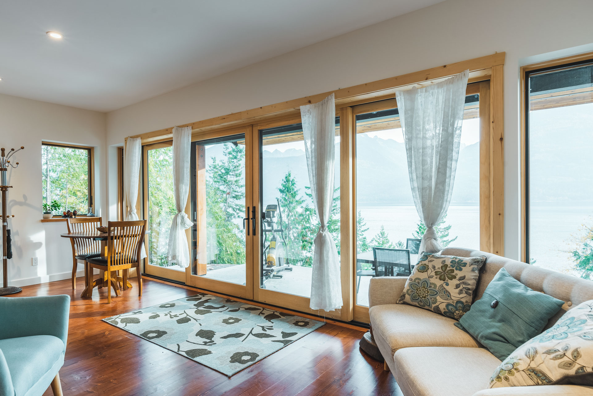 Looking out large windows as a view of Kootenay Lake, home built by Eisenhauer Woodworks in Kaslo BC
