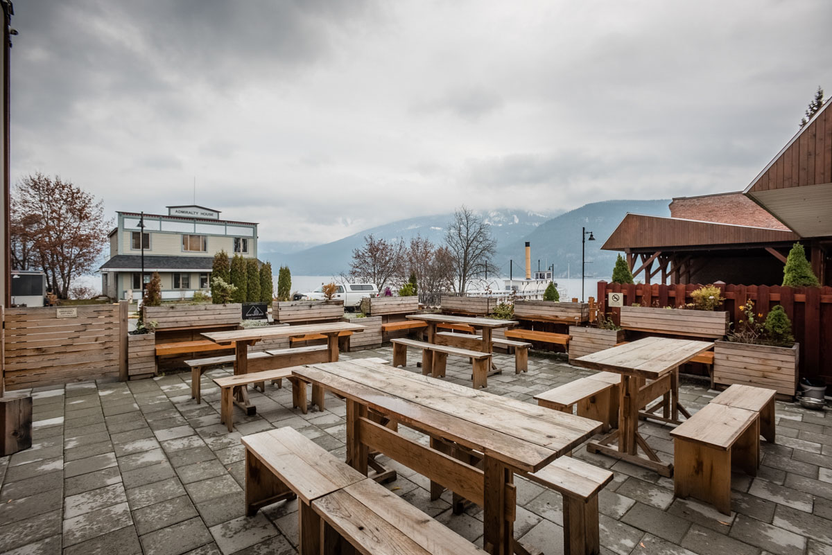 Exterior patio with wood tables and benched of a brewery in Kaslo, BC renovated by Eisenhauer Woodworks